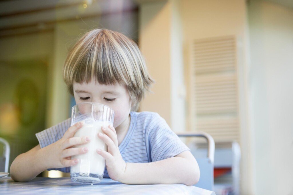 children drinking different types of milk in a sunny kitchen